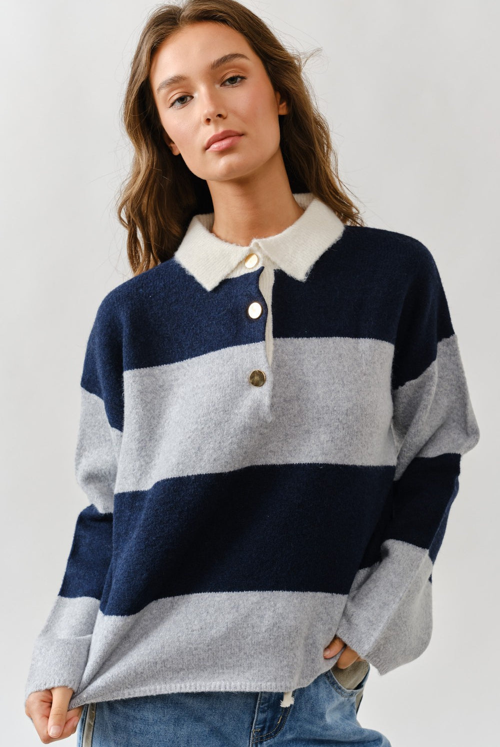 Woman wearing a striped sweater with a collar on a plain background
