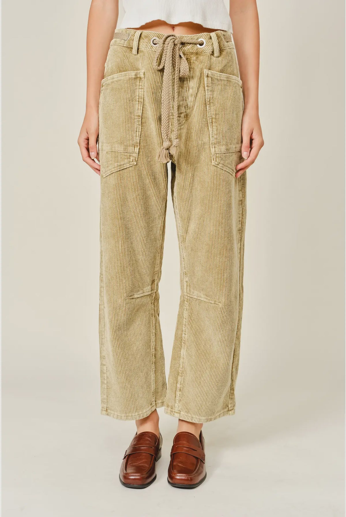 Women’s camel corduroy trousers featuring a subtle barrel fit, utility patch pockets, belt loops, and a rope tie waist.