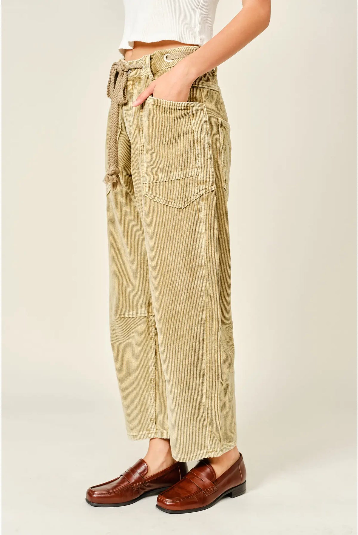 Women’s camel corduroy trousers featuring a subtle barrel fit, utility patch pockets, belt loops, and a rope tie waist.