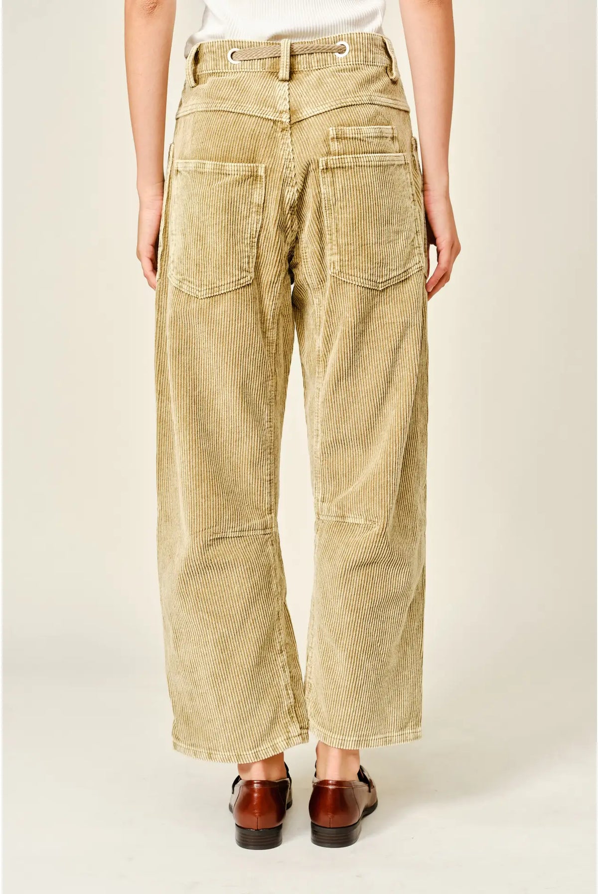 Women’s camel corduroy trousers featuring a subtle barrel fit, utility patch pockets, belt loops, and a rope tie waist.