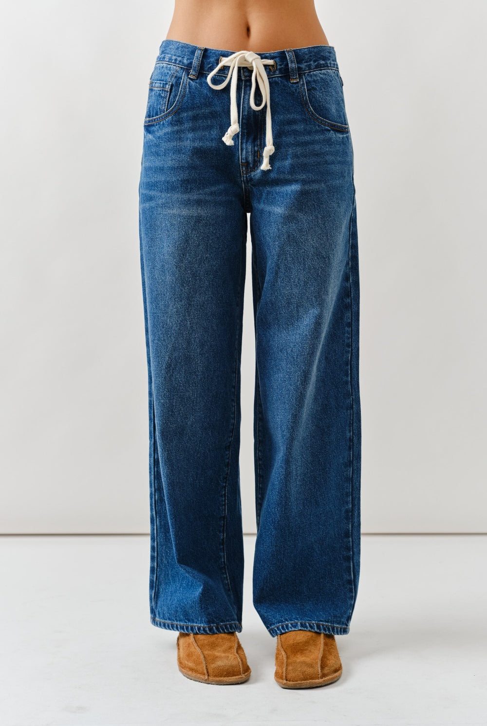 Blue jeans with a drawstring waist on a white background