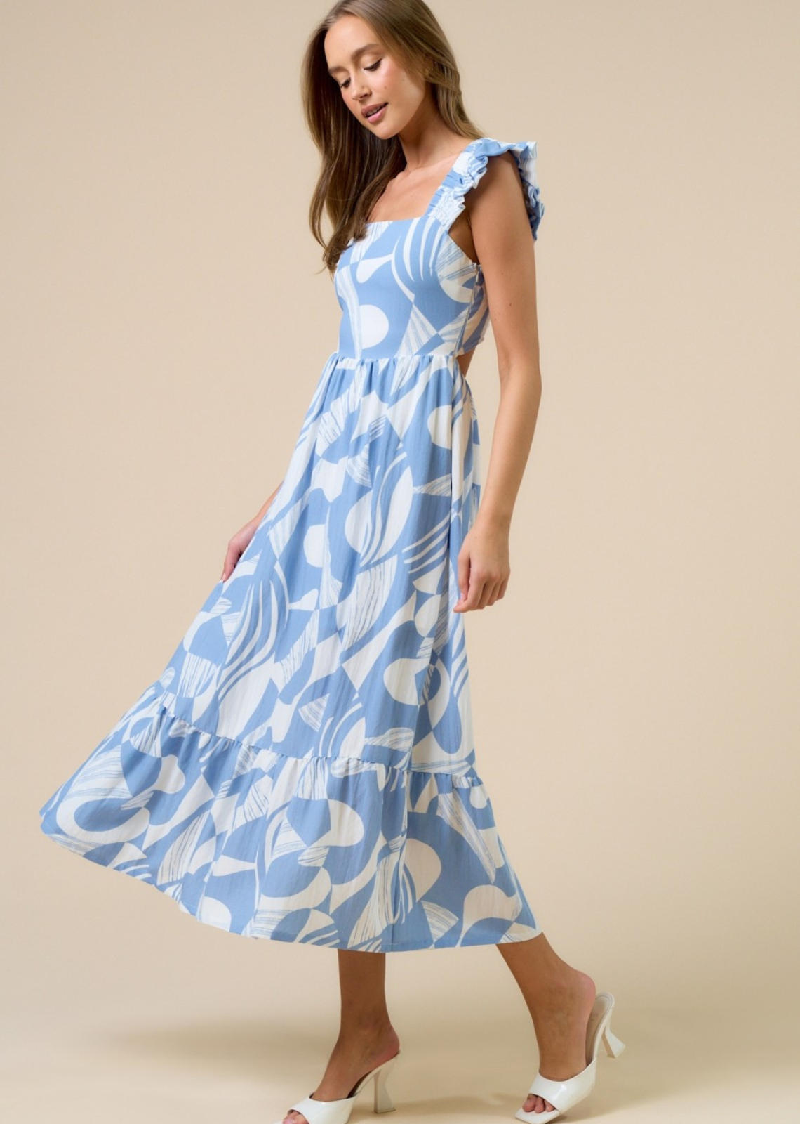 Woman wearing a blue floral dress against a beige background