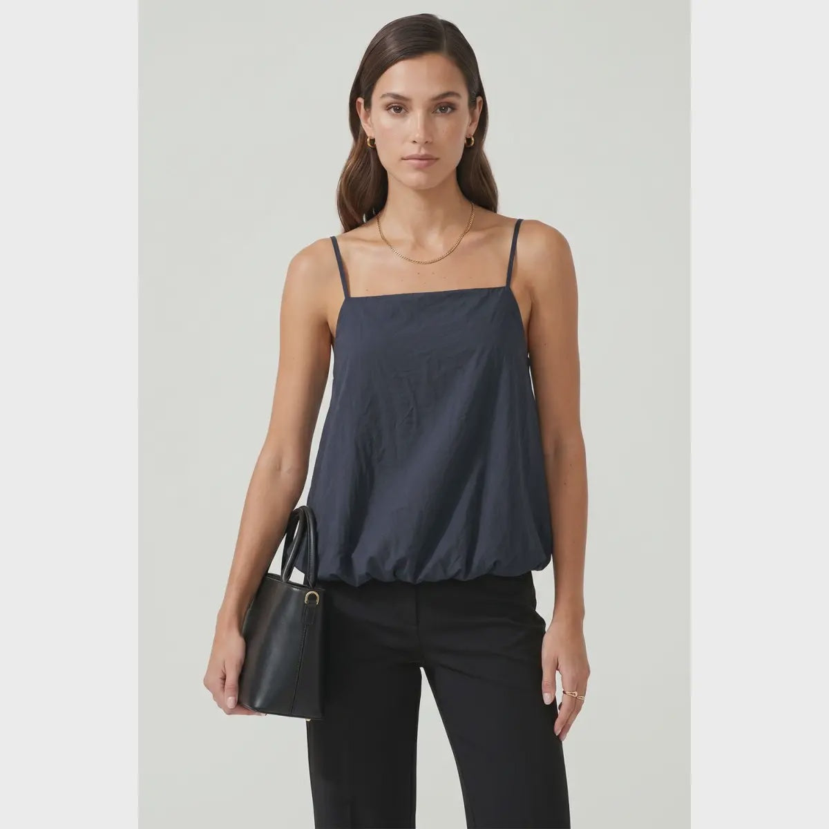 Navy bubble cami tank featuring a square neckline, adjustable spaghetti straps, a relaxed flowy silhouette, and a gathered bubble hem