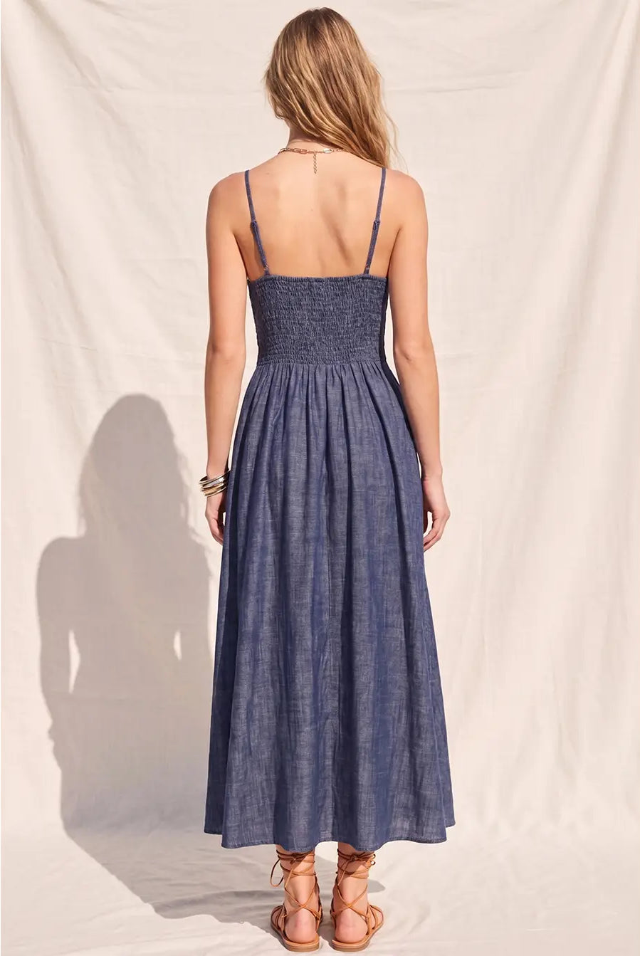 Women's denim fit-and-flare midi dress with a V-neckline, corset waist detailing, adjustable straps, a smocked back, and a flattering feminine silhouette.