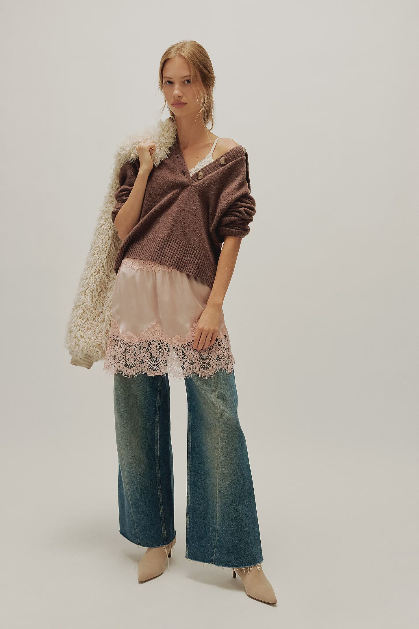 woman wearing a peach coloured satin mini skirt with a lace hem