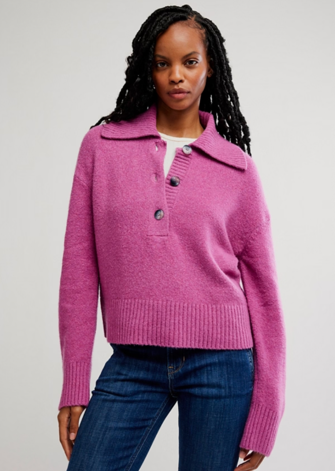 Woman wearing a pink sweater with a white background