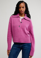 Woman wearing a pink sweater with a white background