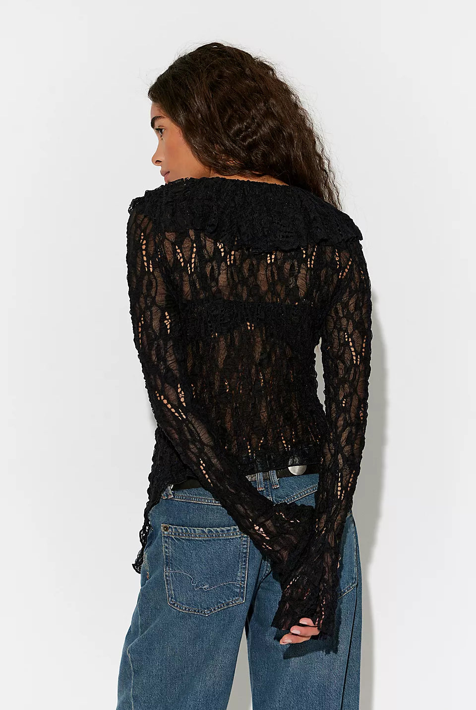Textured lace cardigan in black, featuring a fitted longline silhouette, V-neckline, button-front closure, fitted long sleeves, and cascading ruffle hem detailing.
