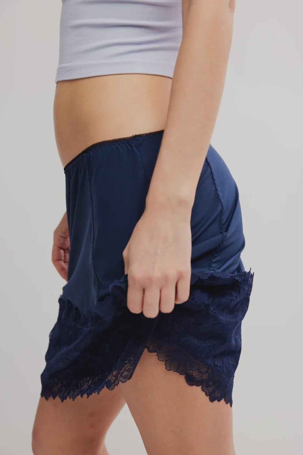 Navy blue lace shorts worn by a person on a plain background
