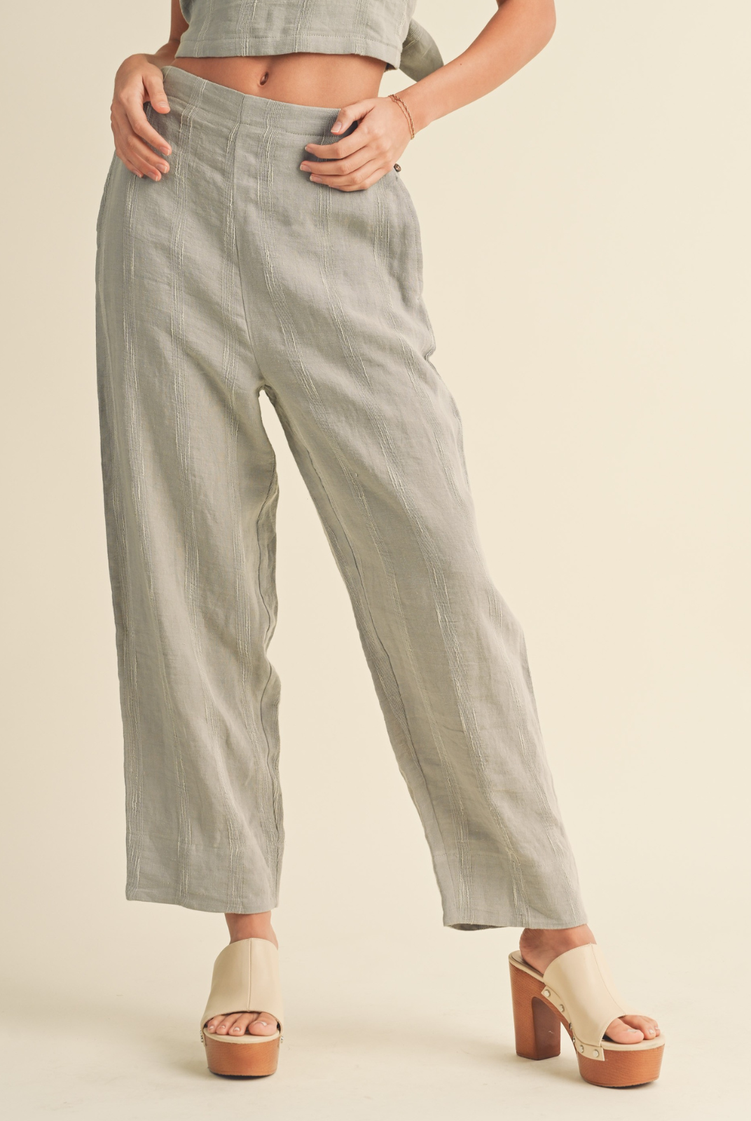 Freida Button-Down PantDiscover the perfect blend of style and comfort with the Miou Muse Freida Button-Down Pant in a refreshing straw color. Made from a high-quality mix of 76% linen, 20% cotton, and 4% polyester, these pants offer a unique texture and a chic side button detail, perfect for adding a touch of elegance to any outfit.