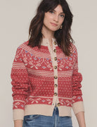 Woman wearing a red and beige patterned cardigan on a plain background