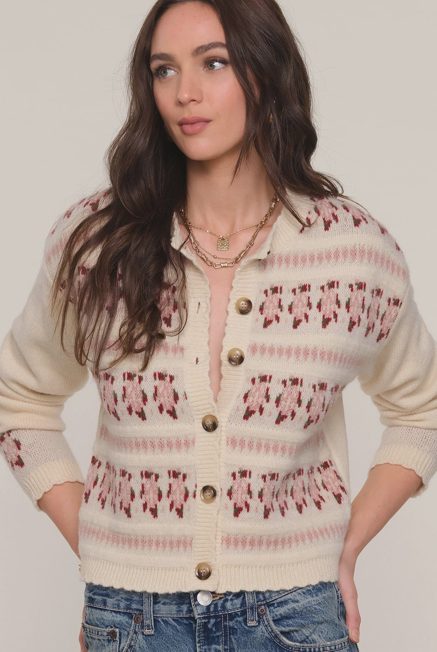 Woman wearing a patterned cardigan with a neutral background