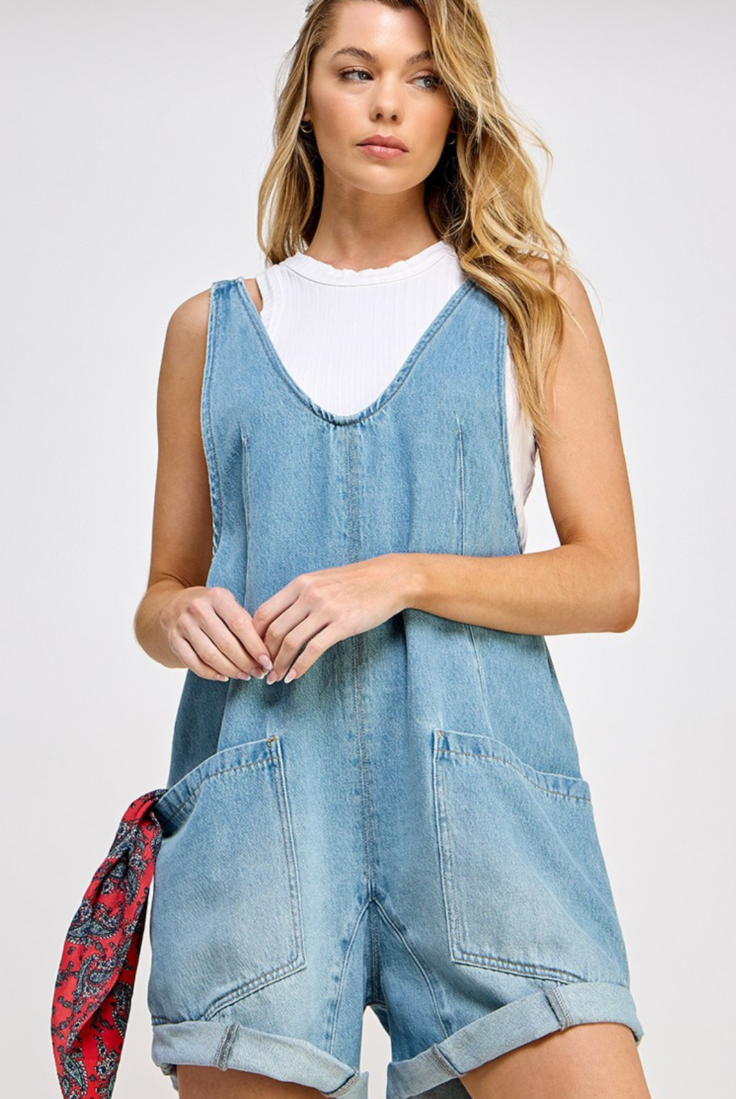 High Roller romper - Denim fabrication, rigid feel, low scoop neckline, seam detail throughout, oversized patch pockets, drop-crotch harem-style legs, low back with adjustable shoulder straps.