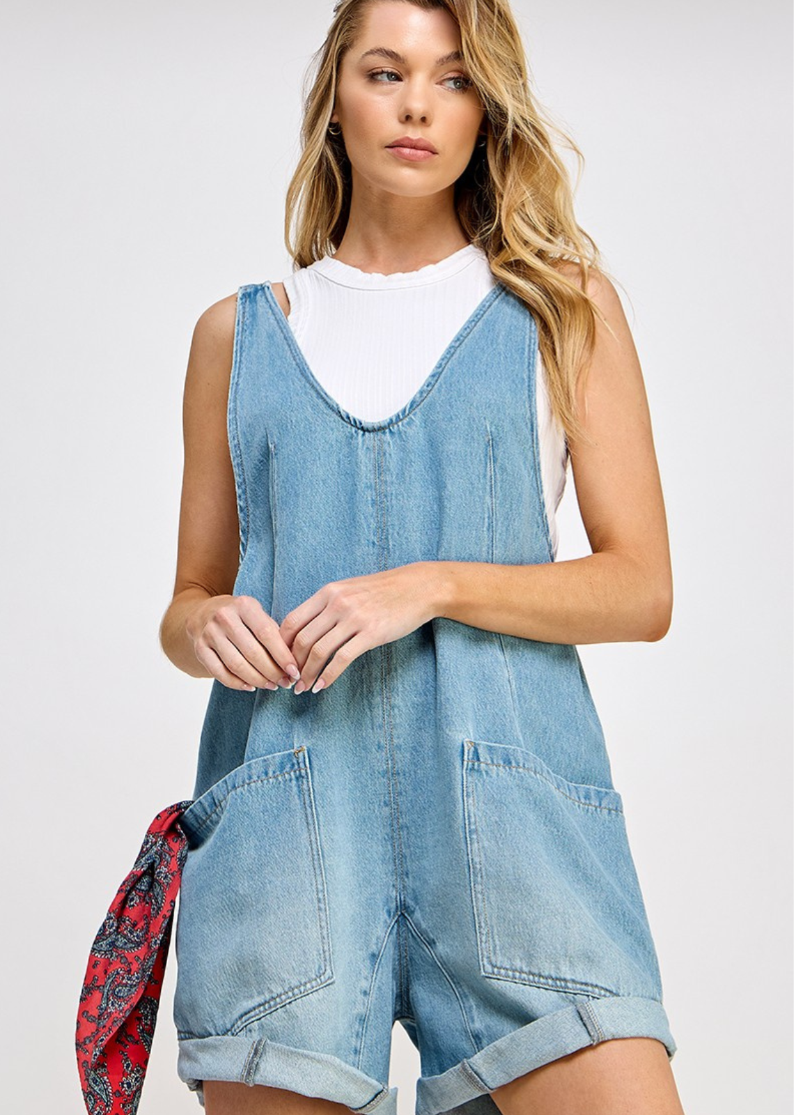 High Roller romper - Denim fabrication, rigid feel, low scoop neckline, seam detail throughout, oversized patch pockets, drop-crotch harem-style legs, low back with adjustable shoulder straps.