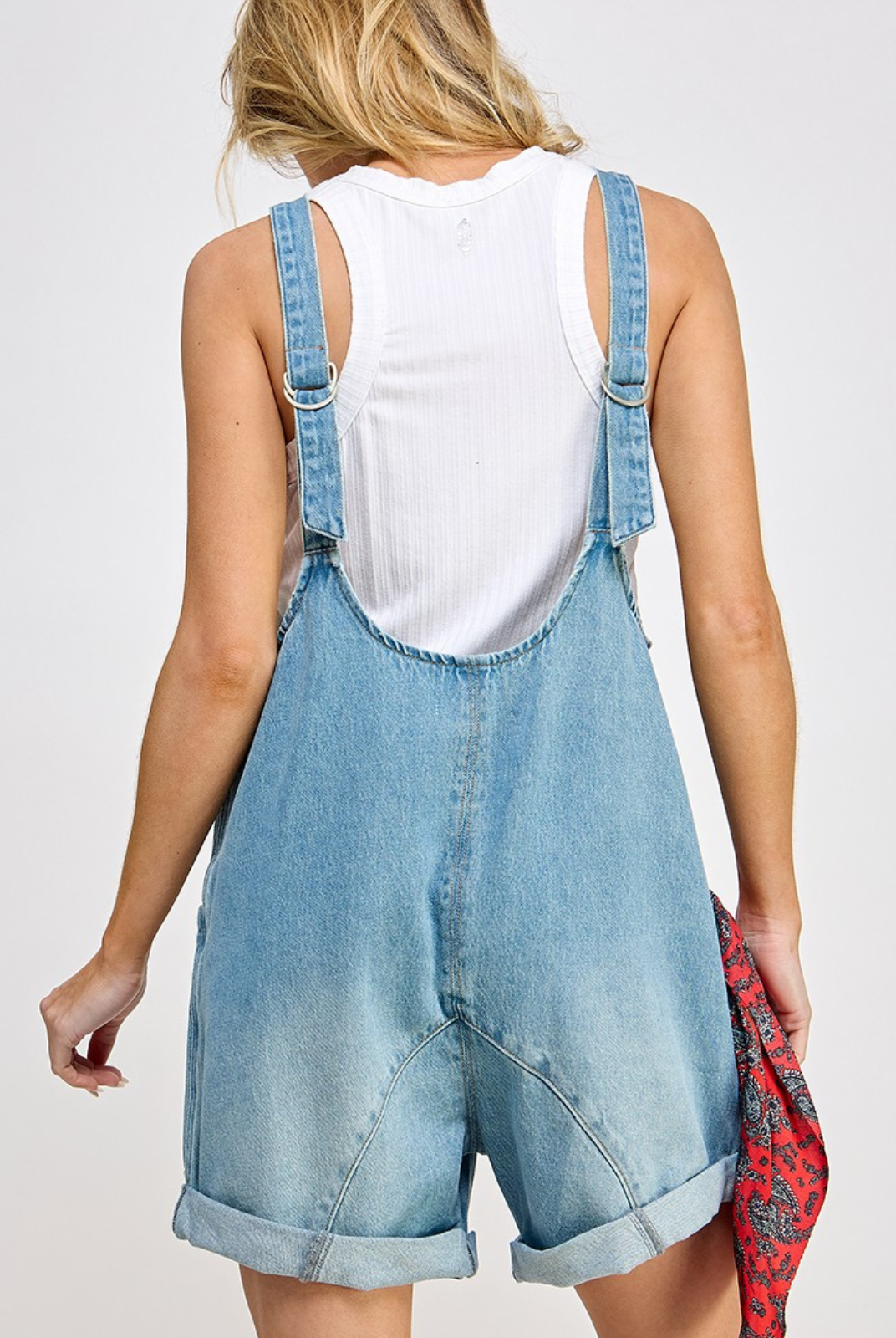 High Roller romper - Denim fabrication, rigid feel, low scoop neckline, seam detail throughout, oversized patch pockets, drop-crotch harem-style legs, low back with adjustable shoulder straps.