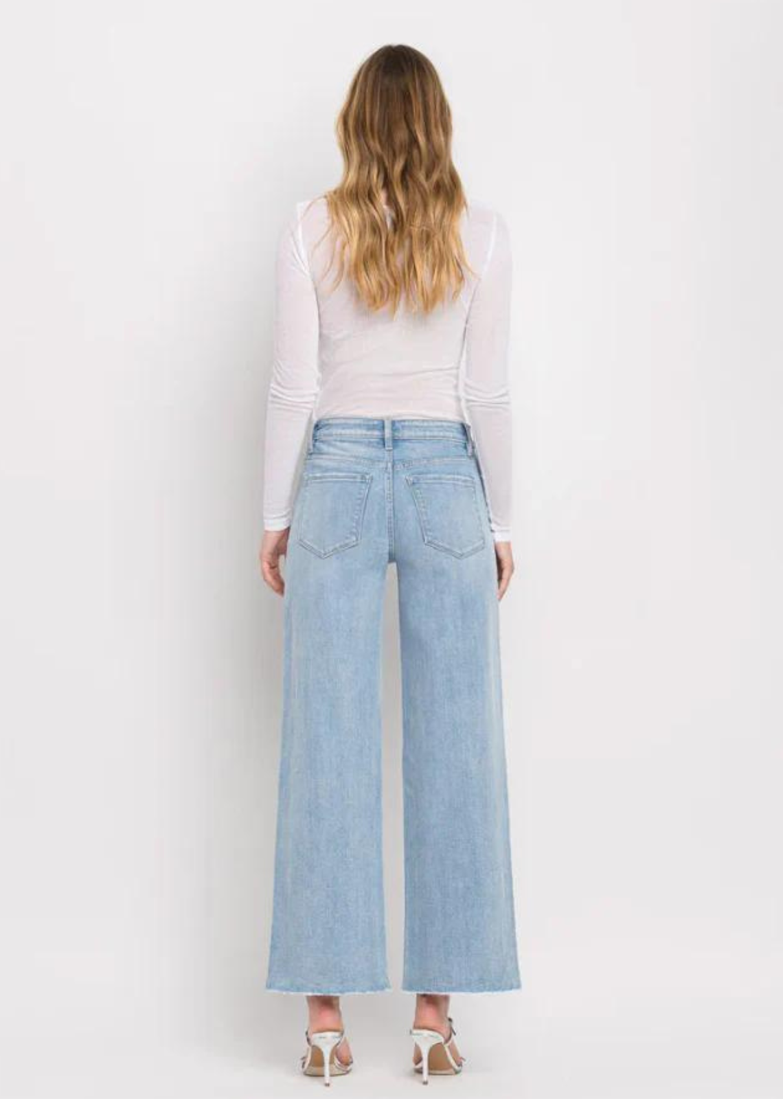 Vervet By Flying Monkey High Rise Wide Leg Jeans -Ben Rinnes. Crafted from comfort stretch denim, these jeans feature a high rise waist that flatters and a raw hem for a trendy touch. The full length and wide leg design offer both comfort and style, making these the perfect addition to any wardrobe.