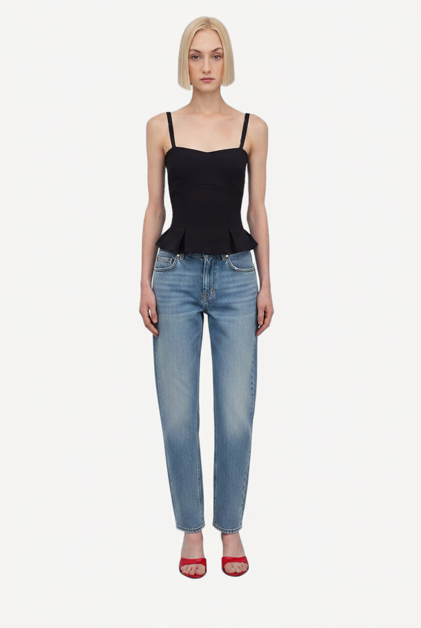 Woman wearing a black peplum top and capri pants on a white background