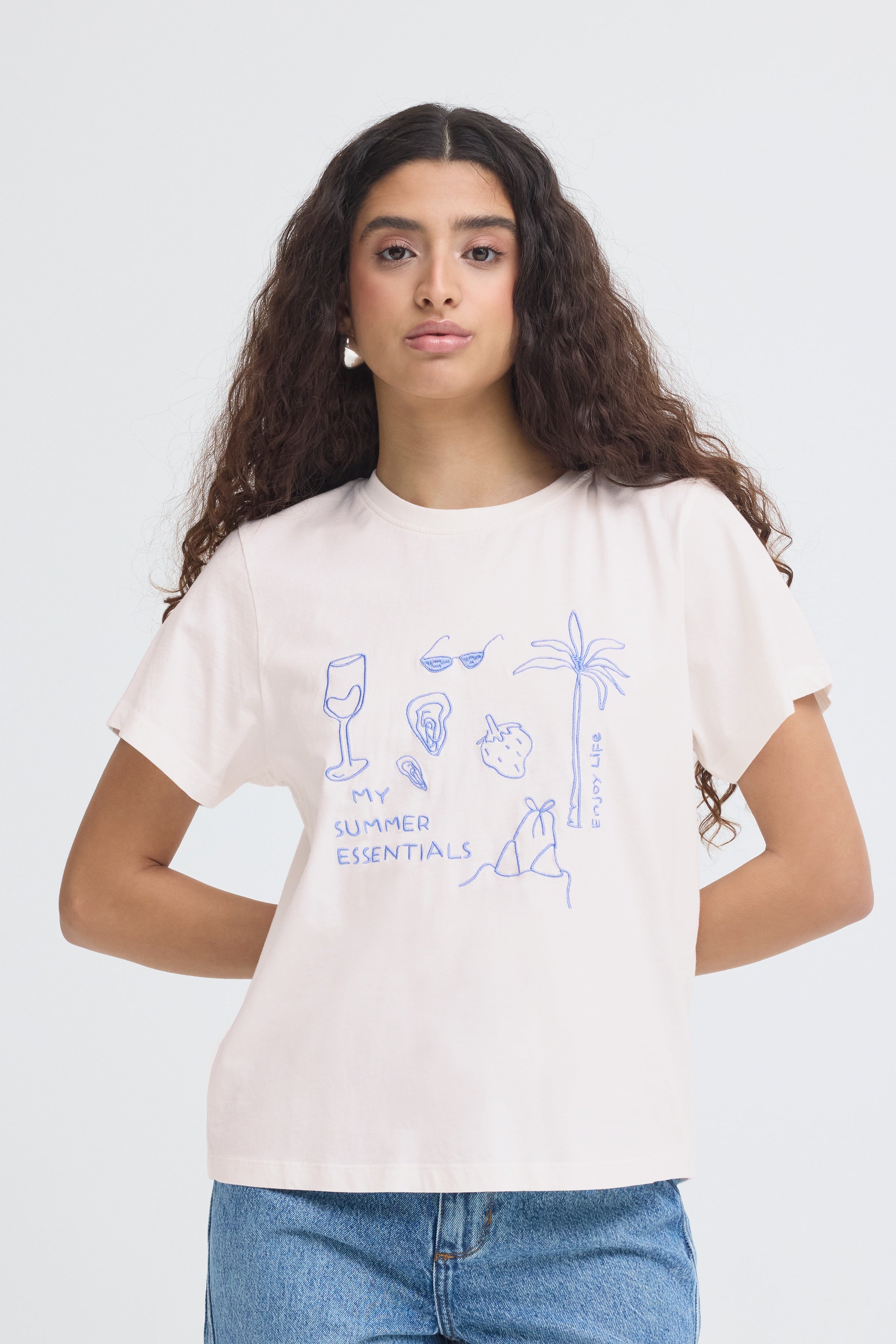 Person wearing a white t-shirt with blue graphics and text on a plain background