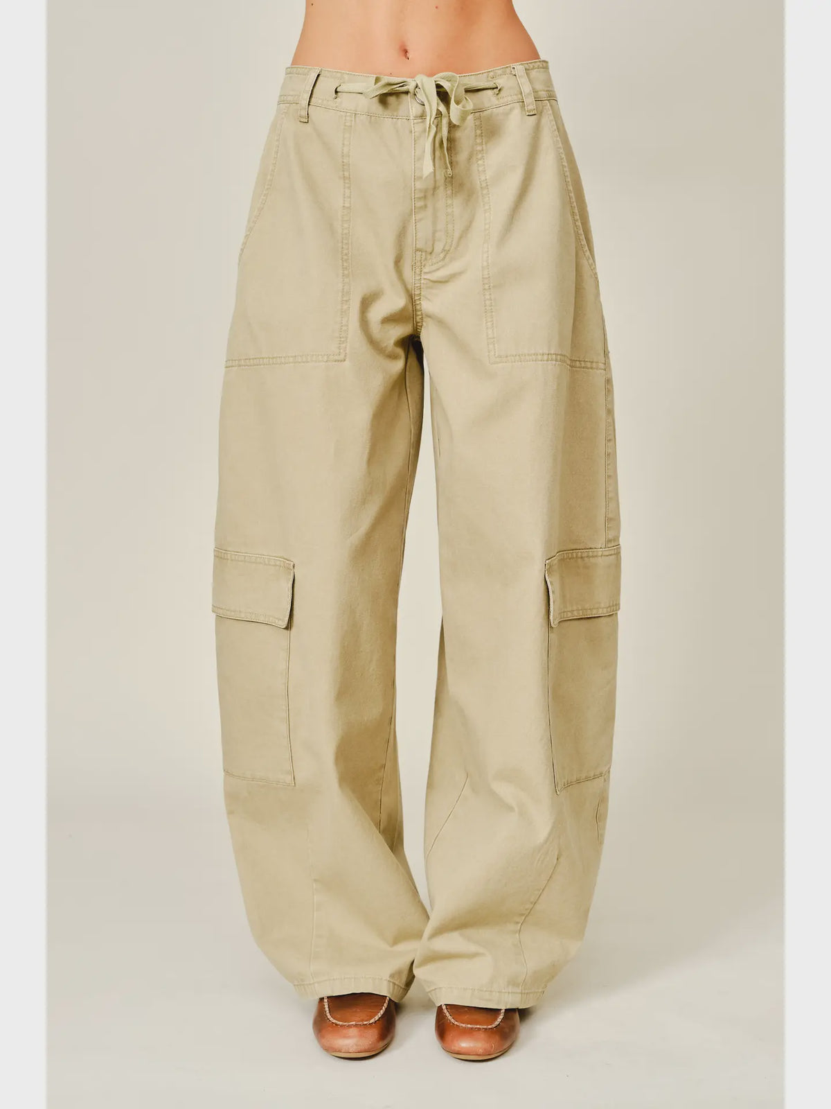 Relaxed barrel-leg pants featuring an adjustable waist tie and functional side pockets, designed in a lightweight fabric for a comfortable, versatile fit.