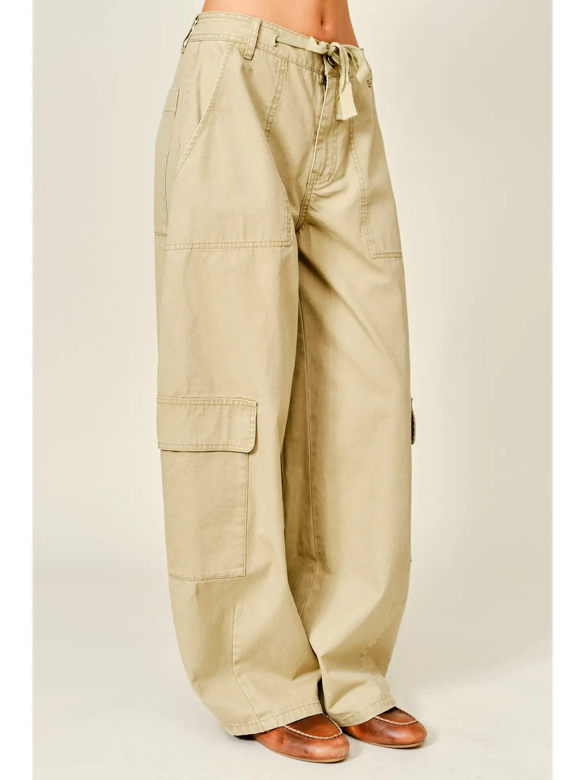 Relaxed barrel-leg pants featuring an adjustable waist tie and functional side pockets, designed in a lightweight fabric for a comfortable, versatile fit.