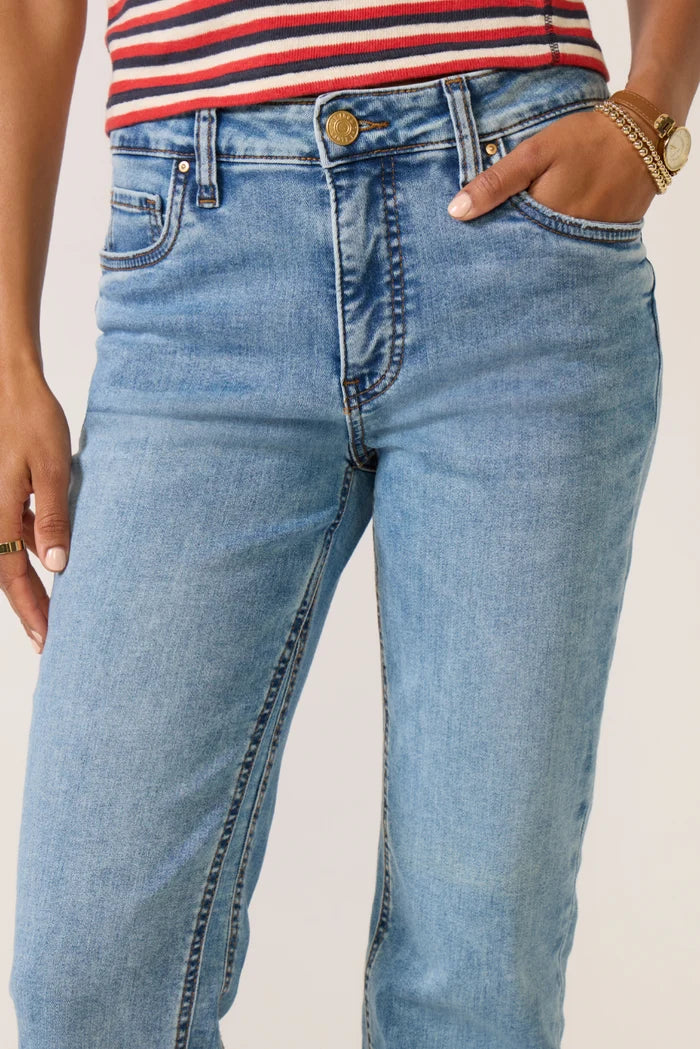 Light-to-medium blue high-rise jeans with a slim fit through the hips and thighs, subtle flared legs, classic five-pocket styling, and raw-cut hems.