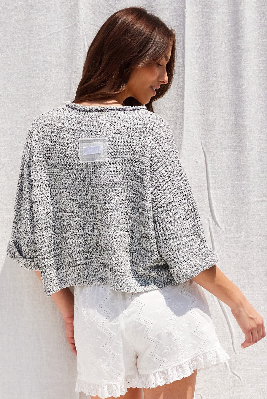 Women's slouchy cropped V-neck sweater in dusty blue with 3/4 sleeves, a relaxed fit, and front and back patch detailing.