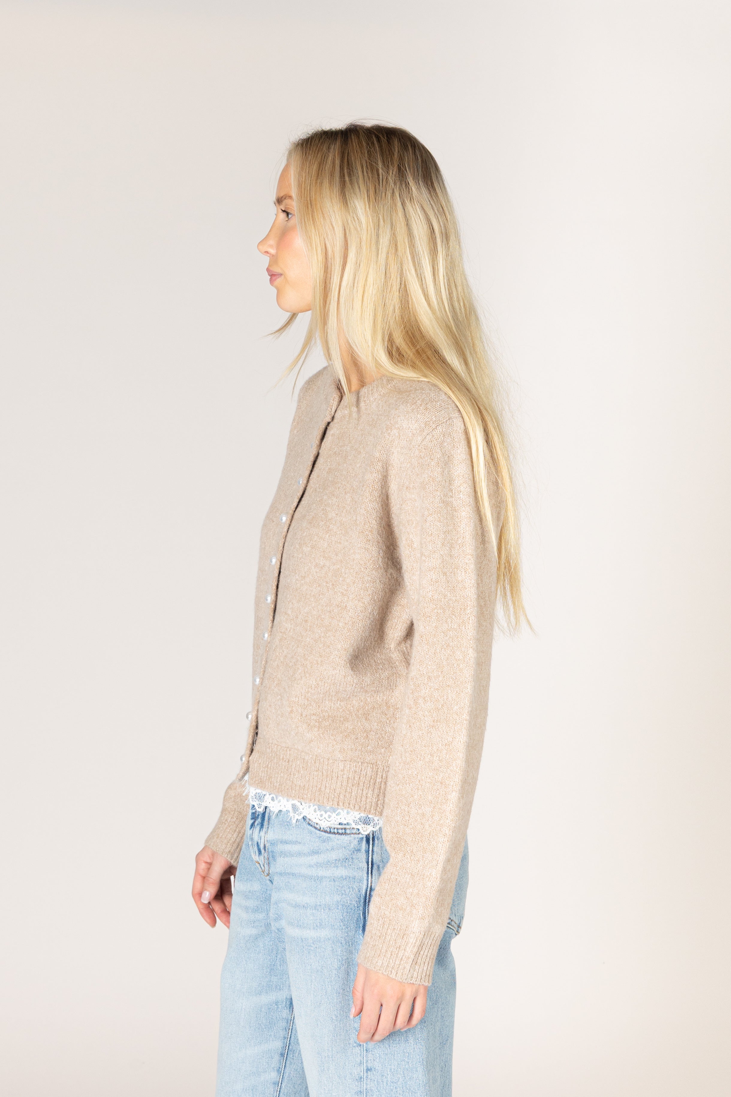 Lightweight knit cardigan featuring a classic crew neckline, button-front closure, long sleeves, and delicate lace trim along the hem and cuffs.