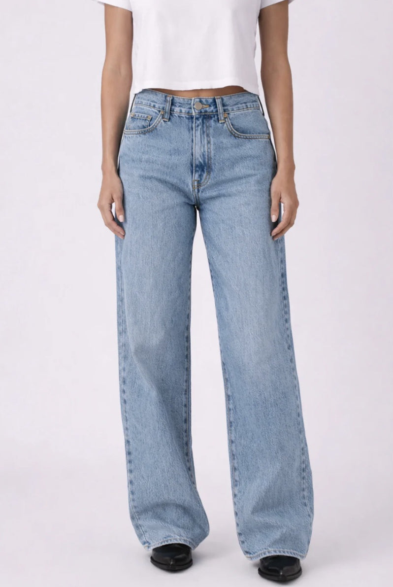 Light blue jeans worn by a person on a white background