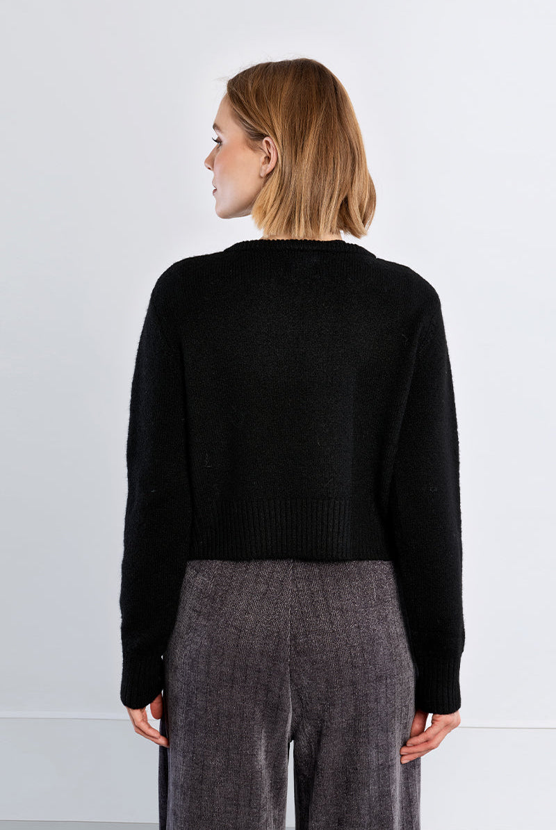 Fluffy knit open cardigan featuring a round neckline, long sleeves, and rhinestone button closure at the upper front.