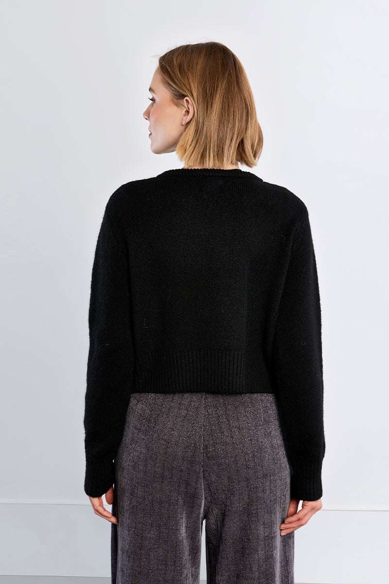 Fluffy knit open cardigan featuring a round neckline, long sleeves, and rhinestone button closure at the upper front.