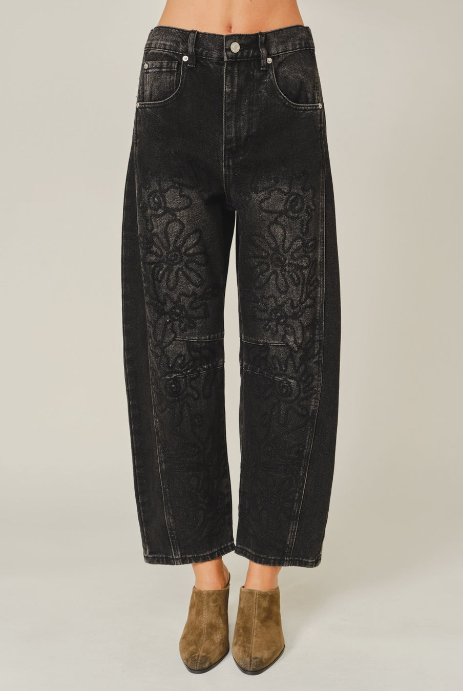 Women’s washed black barrel jeans featuring tonal floral embroidery, high-rise waist, five-pocket styling, relaxed curved leg, and cropped ankle-length fit.