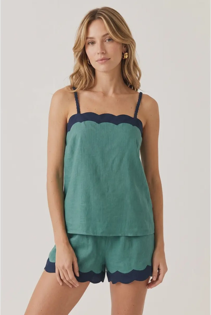 Green linen-blend tank top featuring a cream scalloped neckline, braided adjustable spaghetti straps, a relaxed fit, and a lightweight woven finish. Designed with a back keyhole and button closure