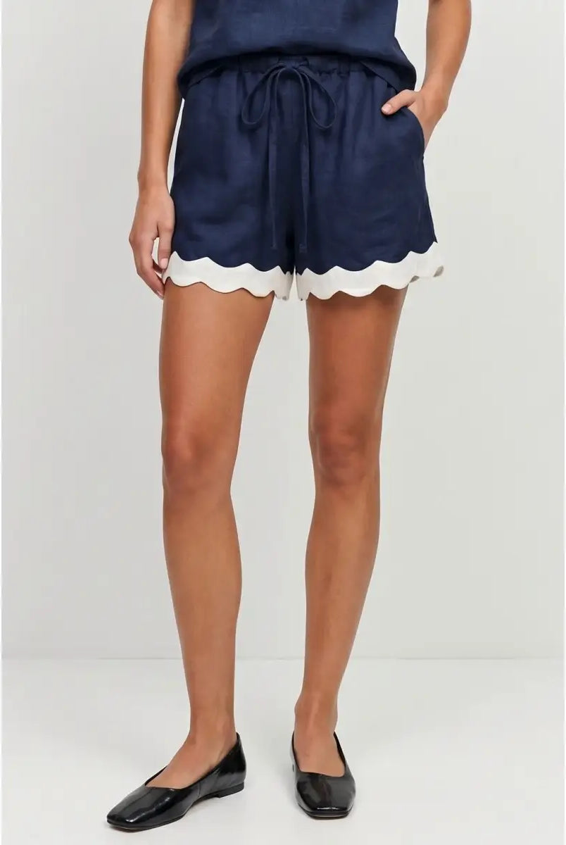 Navy linen-blend pull-on shorts featuring scalloped hems, side pockets, and a self-fabric drawstring waistband