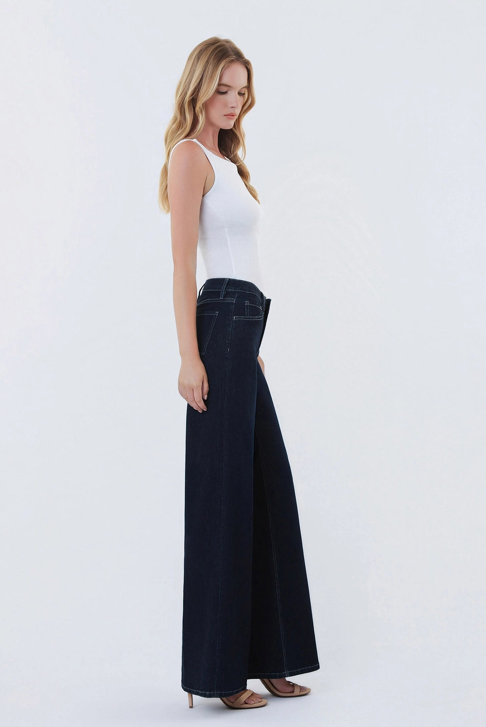 Dark wash wide-leg jeans featuring a mid-rise waist, trouser-inspired front crease, classic five-pocket design, finished hem, and full-length silhouette.
