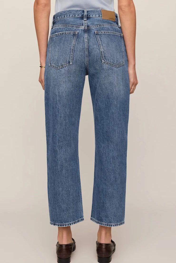 Vintage-wash blue mid-rise jeans featuring a relaxed bowed-leg silhouette, ankle-length hem, and classic five-pocket styling.