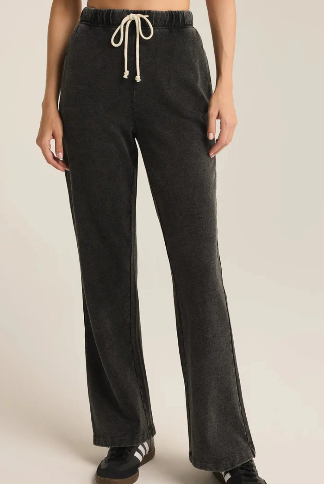 Dark gray sweatpants with a drawstring on a beige background