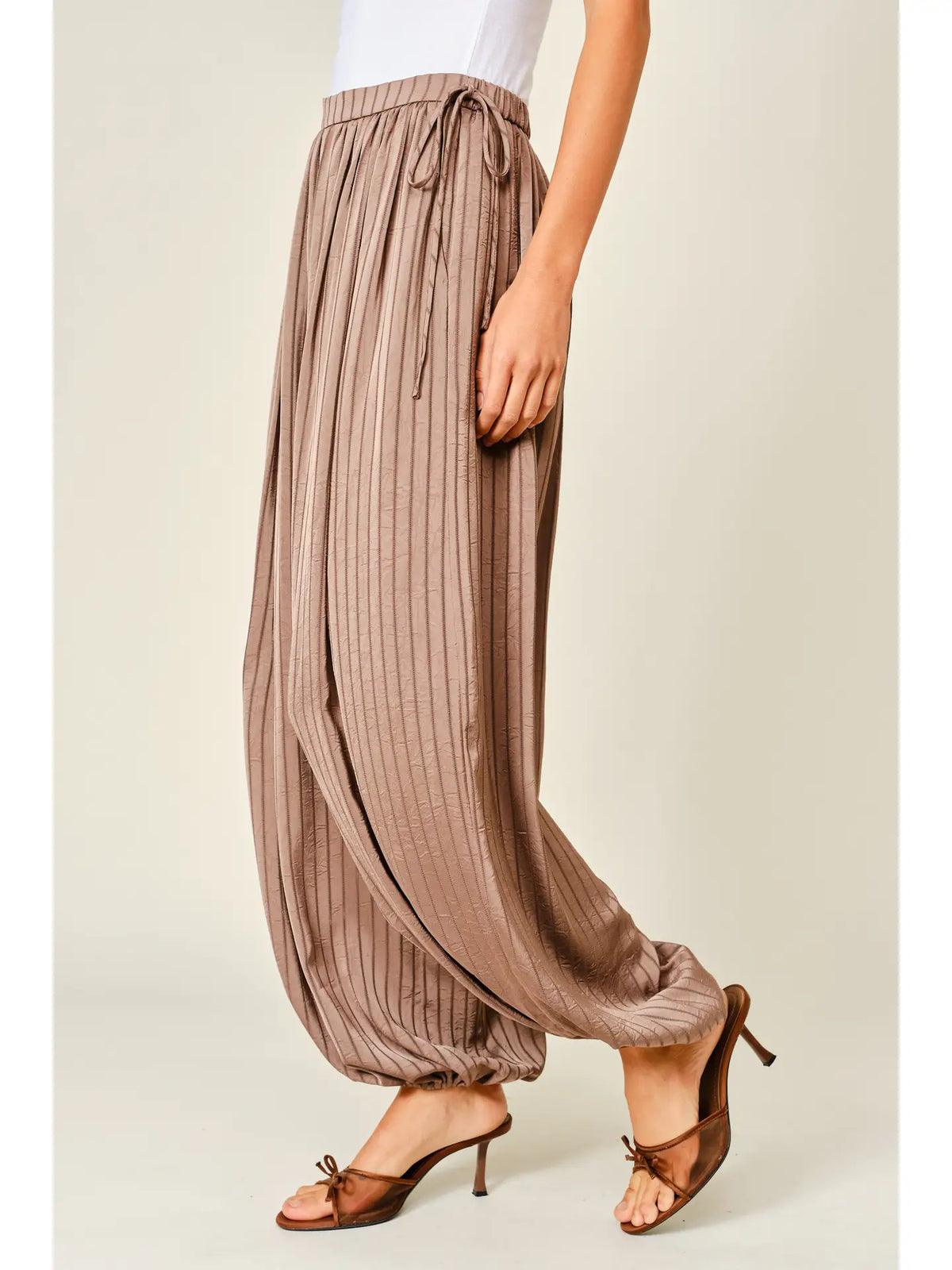 Zola Striped Satin Bubble Pants featuring a soft, glossy satin finish with a striped pattern, comfortable elastic waistband, adjustable drawstring side details, and functional side pockets. Designed with a relaxed, voluminous balloon silhouette and a flowy, lightweight feel for an effortlessly chic look.