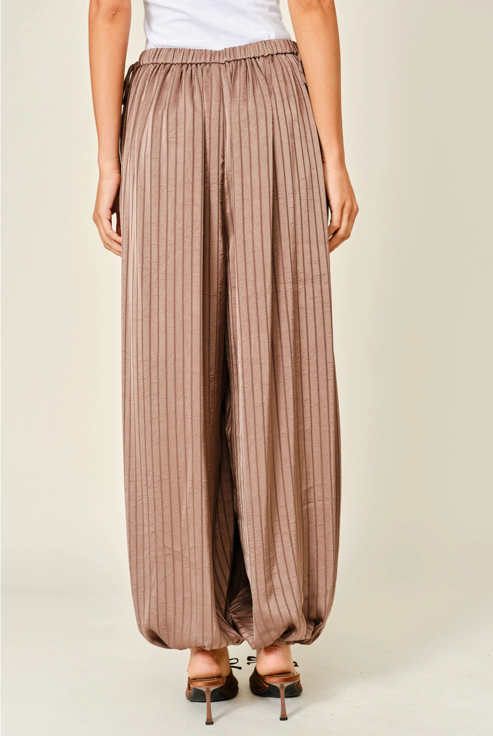 Zola Striped Satin Bubble Pants featuring a soft, glossy satin finish with a striped pattern, comfortable elastic waistband, adjustable drawstring side details, and functional side pockets. Designed with a relaxed, voluminous balloon silhouette and a flowy, lightweight feel for an effortlessly chic look.