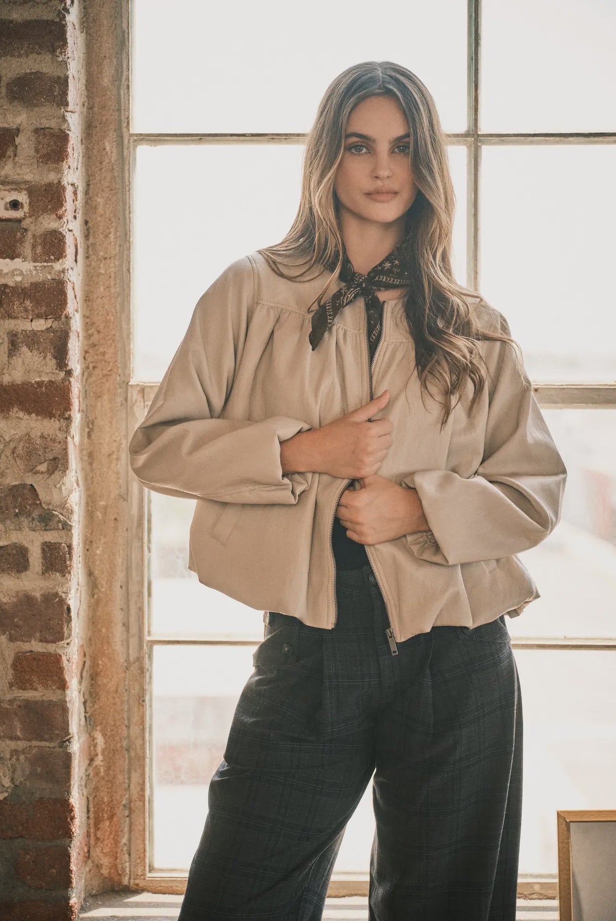 Women’s dove bomber jacket featuring a relaxed fit, zip-front closure, voluminous long sleeves, side pockets, and gathered hem detailing.