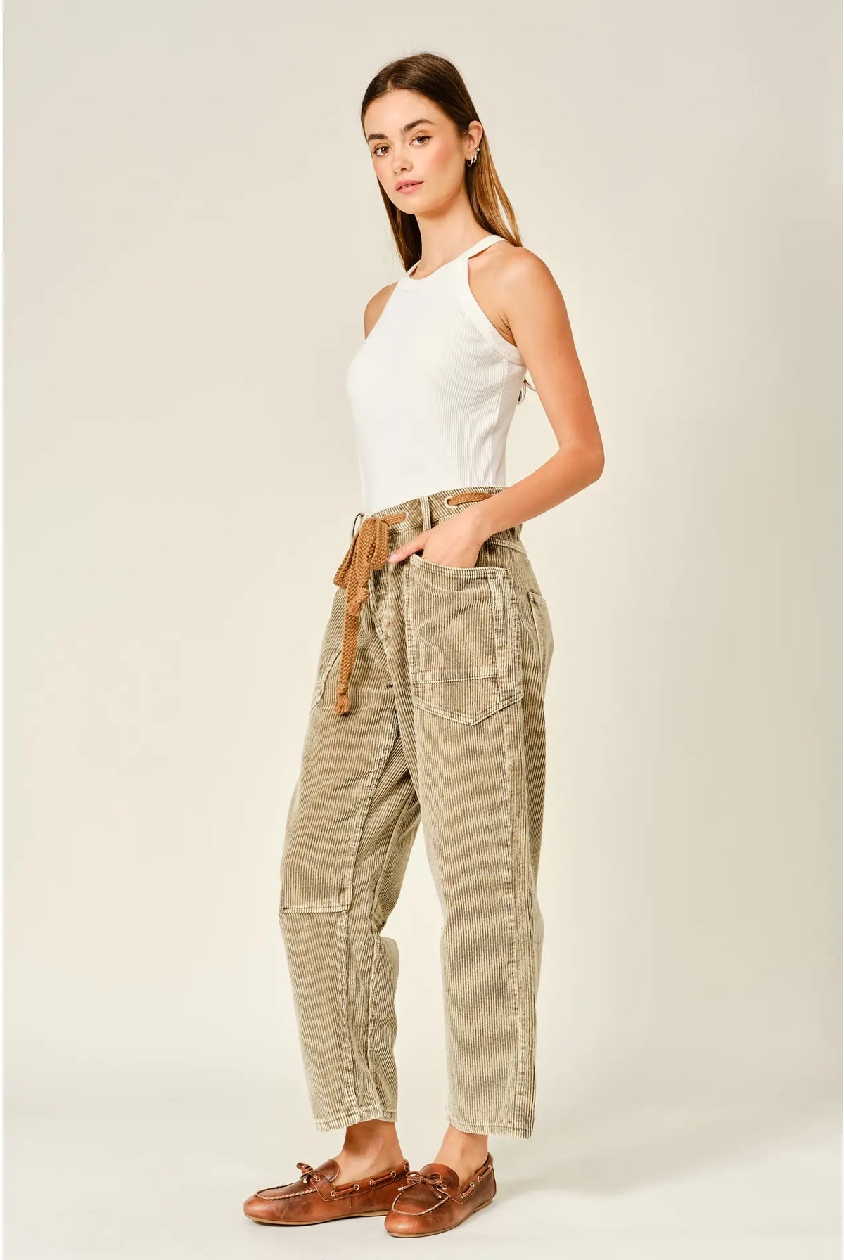 Women’s camel corduroy trousers featuring a subtle barrel fit, utility patch pockets, belt loops, and a rope tie waist.