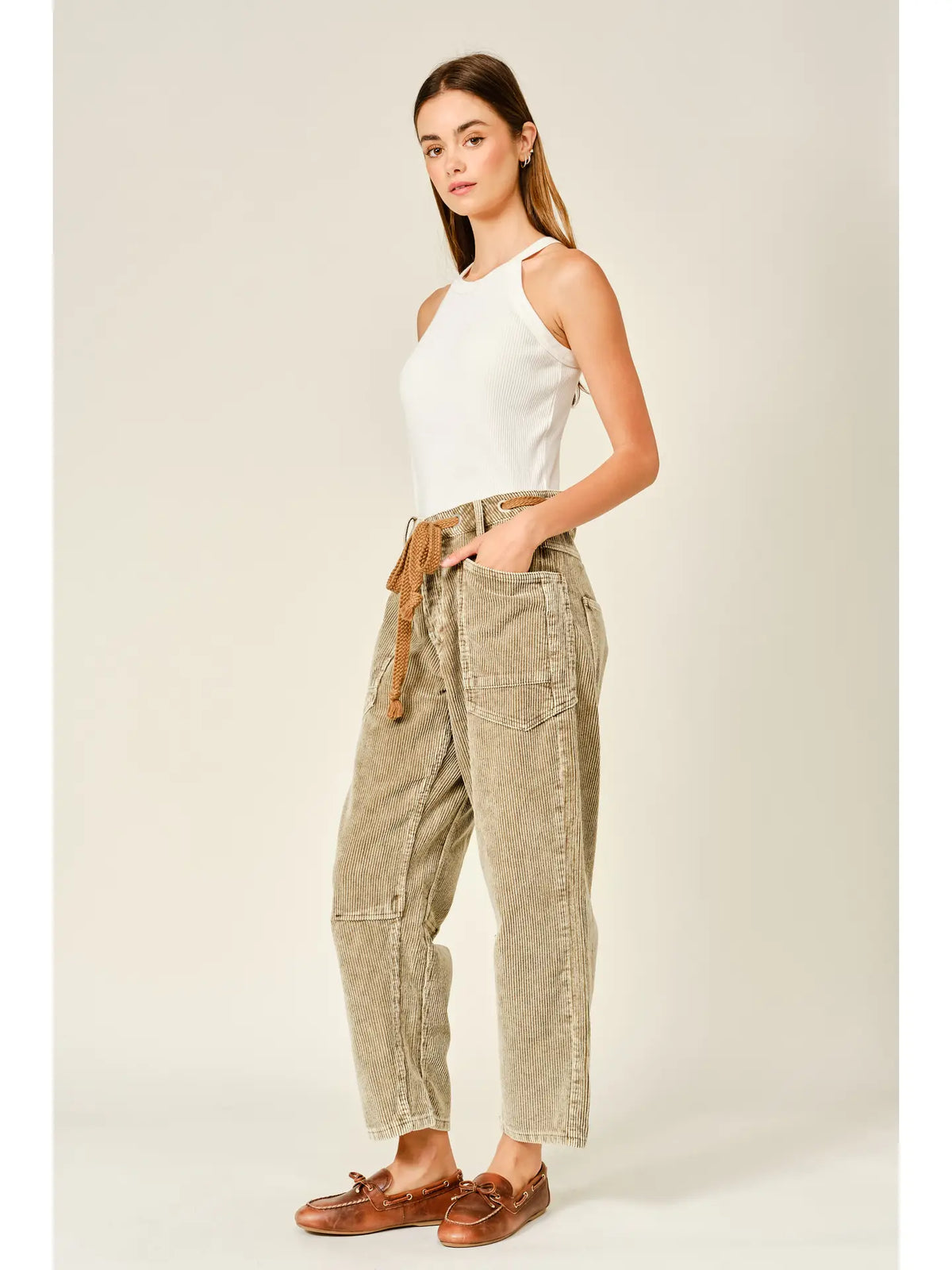 Women’s camel corduroy trousers featuring a subtle barrel fit, utility patch pockets, belt loops, and a rope tie waist.