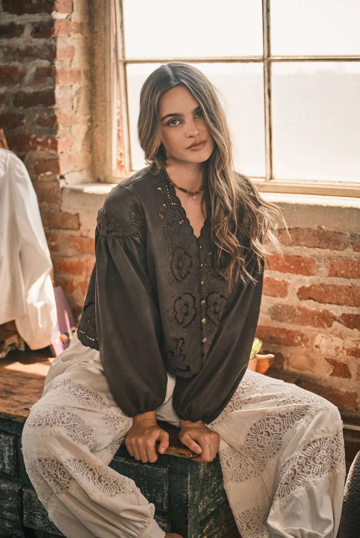 Women’s brown boho blouse featuring tonal floral embroidery, scalloped V-neckline, button-front closure, and relaxed long balloon sleeves.