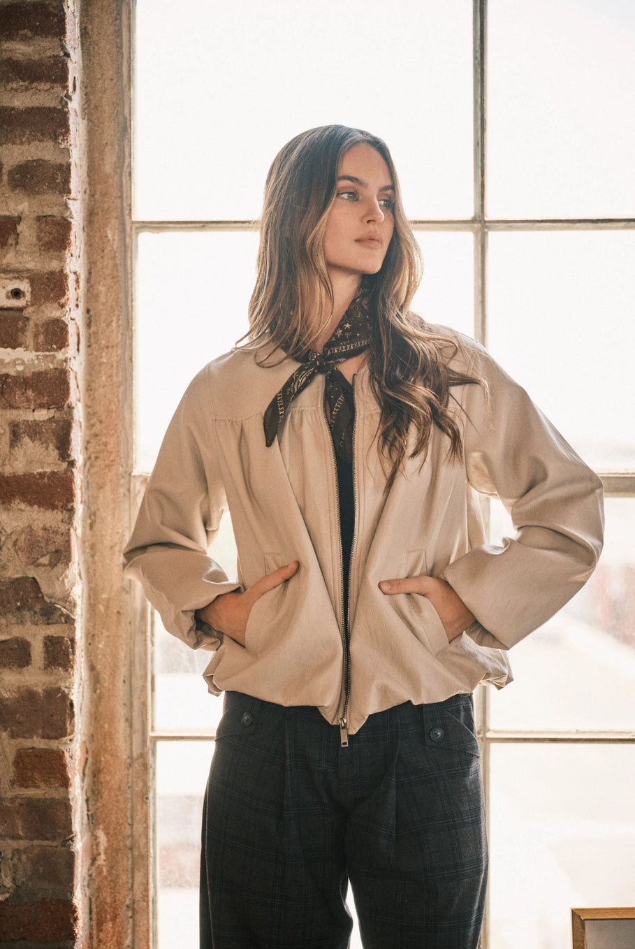 Women’s dove bomber jacket featuring a relaxed fit, zip-front closure, voluminous long sleeves, side pockets, and gathered hem detailing.