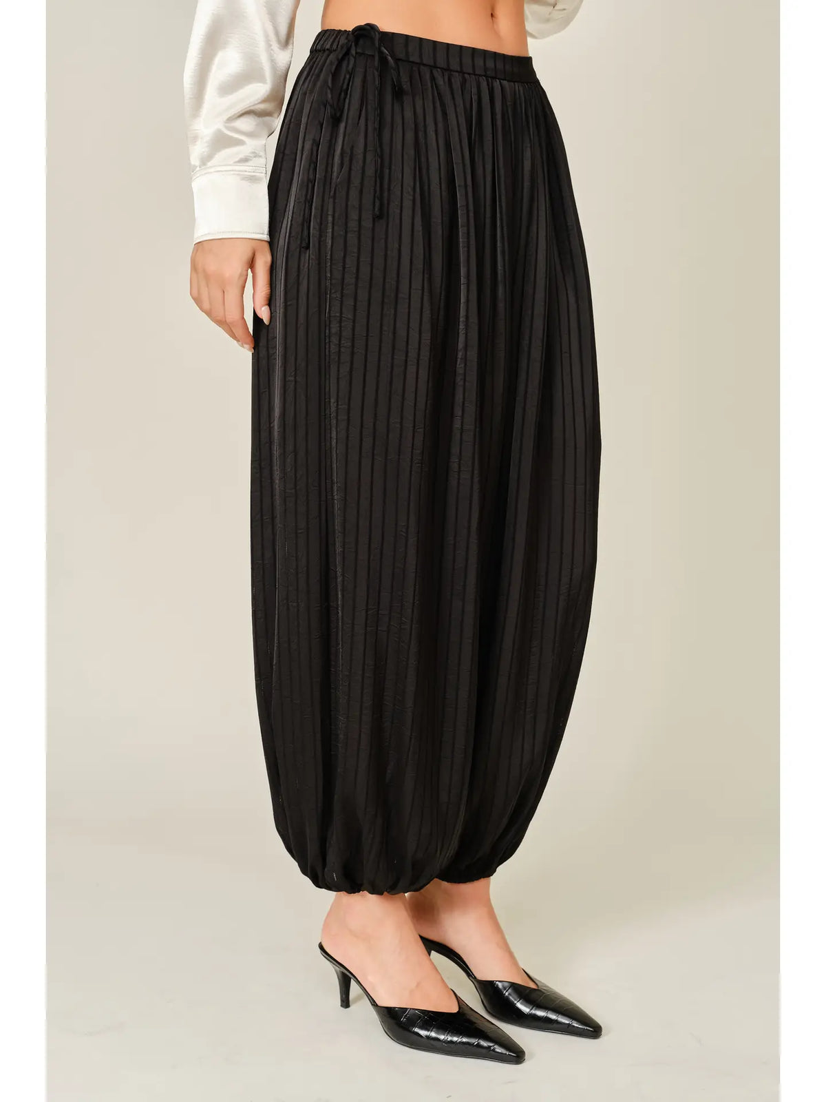 Zola Striped Satin Bubble Pants featuring a soft, glossy satin finish with a striped pattern, comfortable elastic waistband, adjustable drawstring side details, and functional side pockets. Designed with a relaxed, voluminous balloon silhouette and a flowy, lightweight feel for an effortlessly chic look.