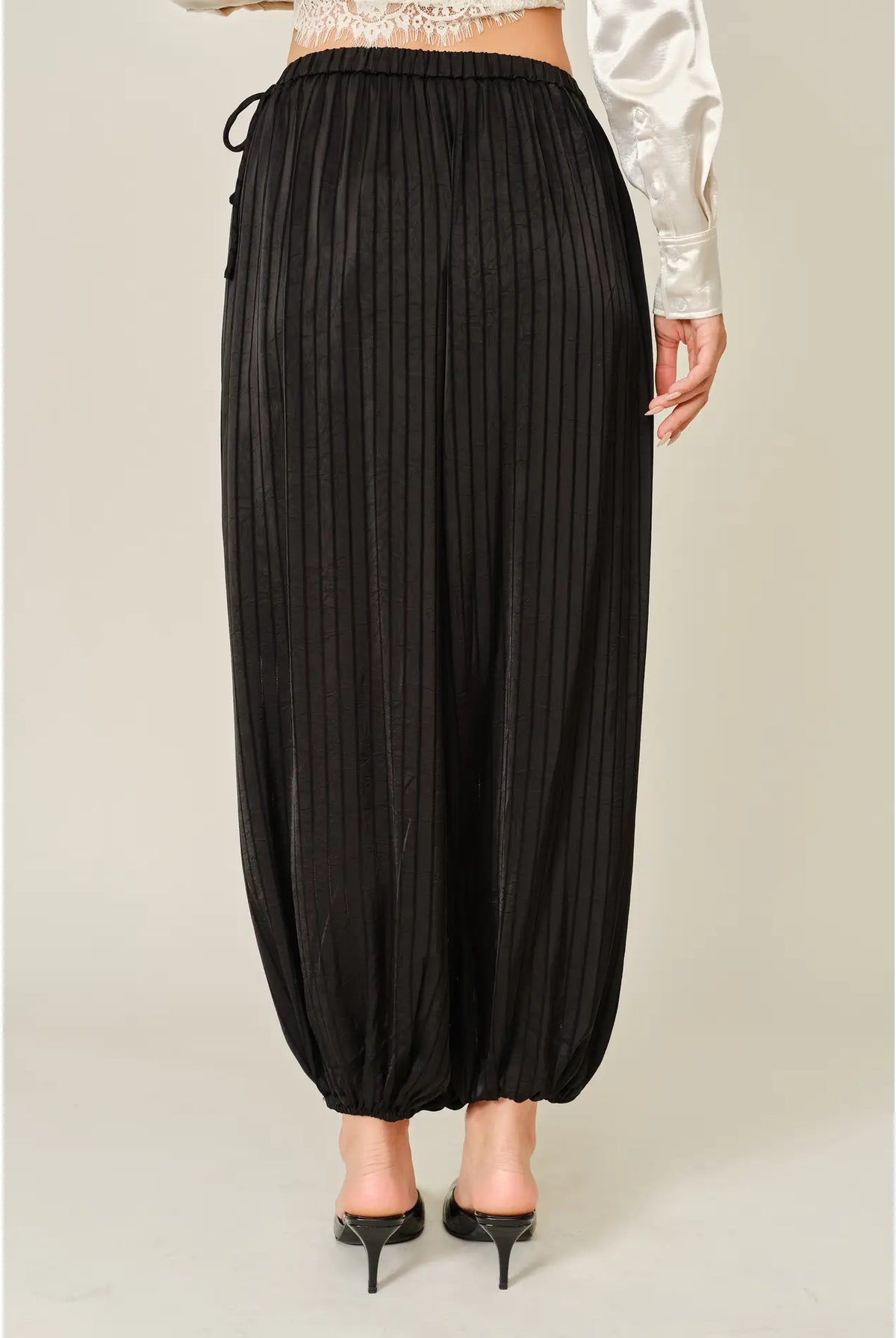 Zola Striped Satin Bubble Pants featuring a soft, glossy satin finish with a striped pattern, comfortable elastic waistband, adjustable drawstring side details, and functional side pockets. Designed with a relaxed, voluminous balloon silhouette and a flowy, lightweight feel for an effortlessly chic look.