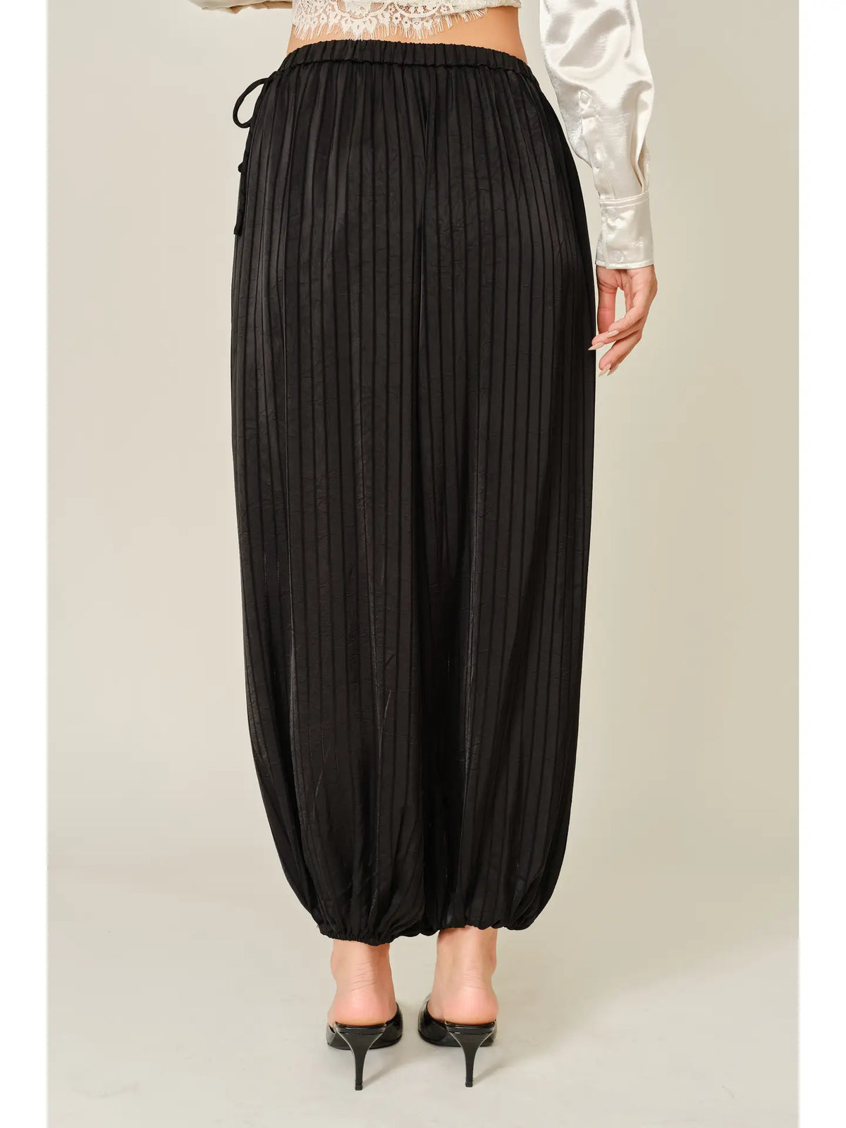 Zola Striped Satin Bubble Pants featuring a soft, glossy satin finish with a striped pattern, comfortable elastic waistband, adjustable drawstring side details, and functional side pockets. Designed with a relaxed, voluminous balloon silhouette and a flowy, lightweight feel for an effortlessly chic look.