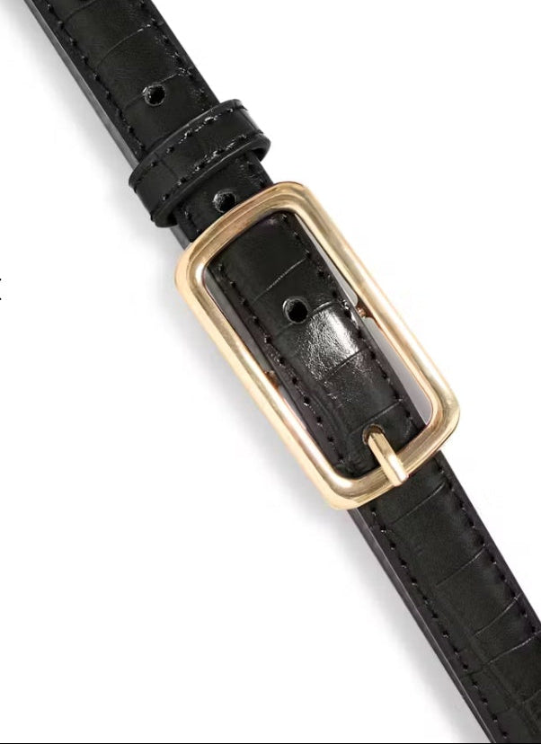 Black leather belt with a gold buckle on a white background