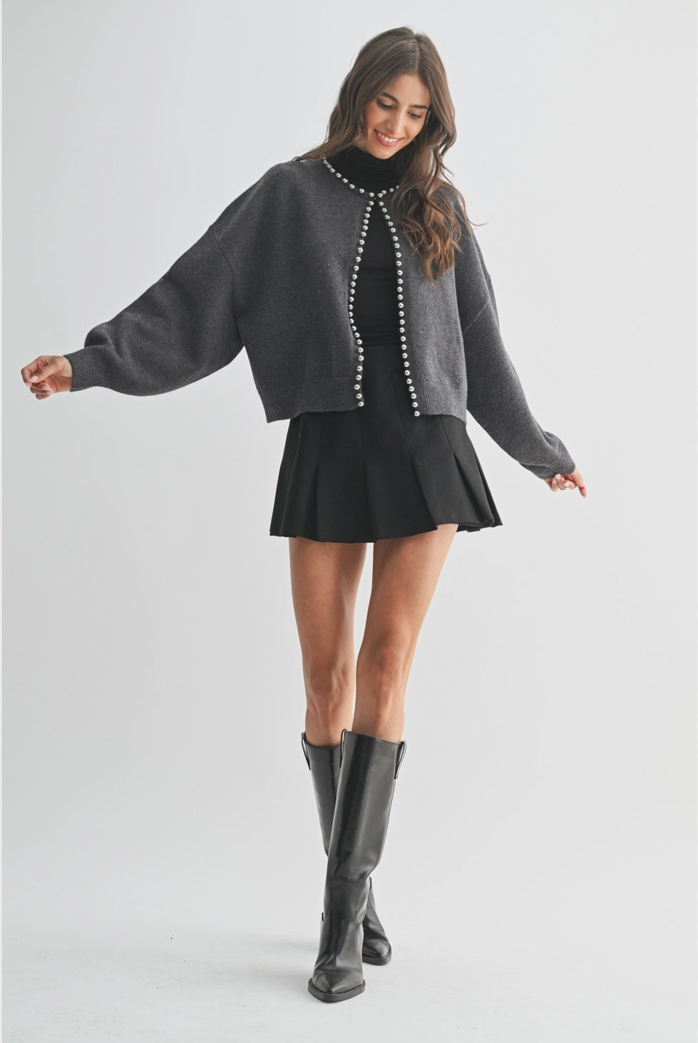 The Celeste Cardigan in a soft knit fabric, featuring delicate pearl detailing, a button-front design, and an elegant feminine silhouette.