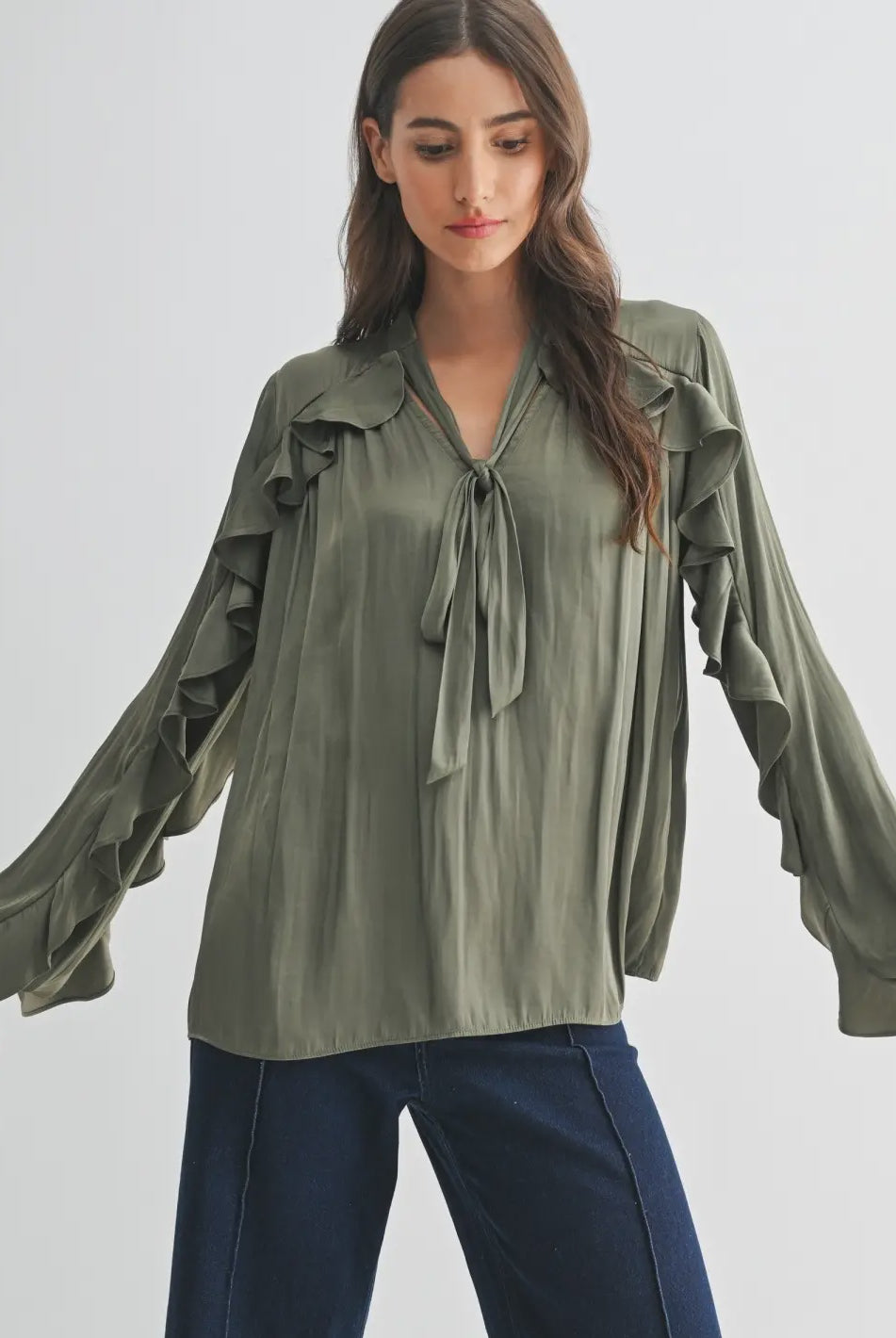 The Juliette Ruffle Blouse in olive green, featuring delicate ruffle detailing and a soft, silky finish.