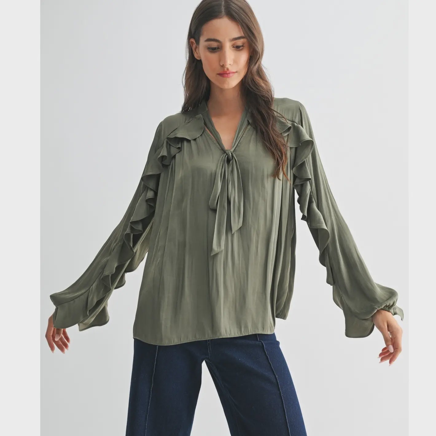The Juliette Ruffle Blouse in olive green, featuring delicate ruffle detailing and a soft, silky finish.